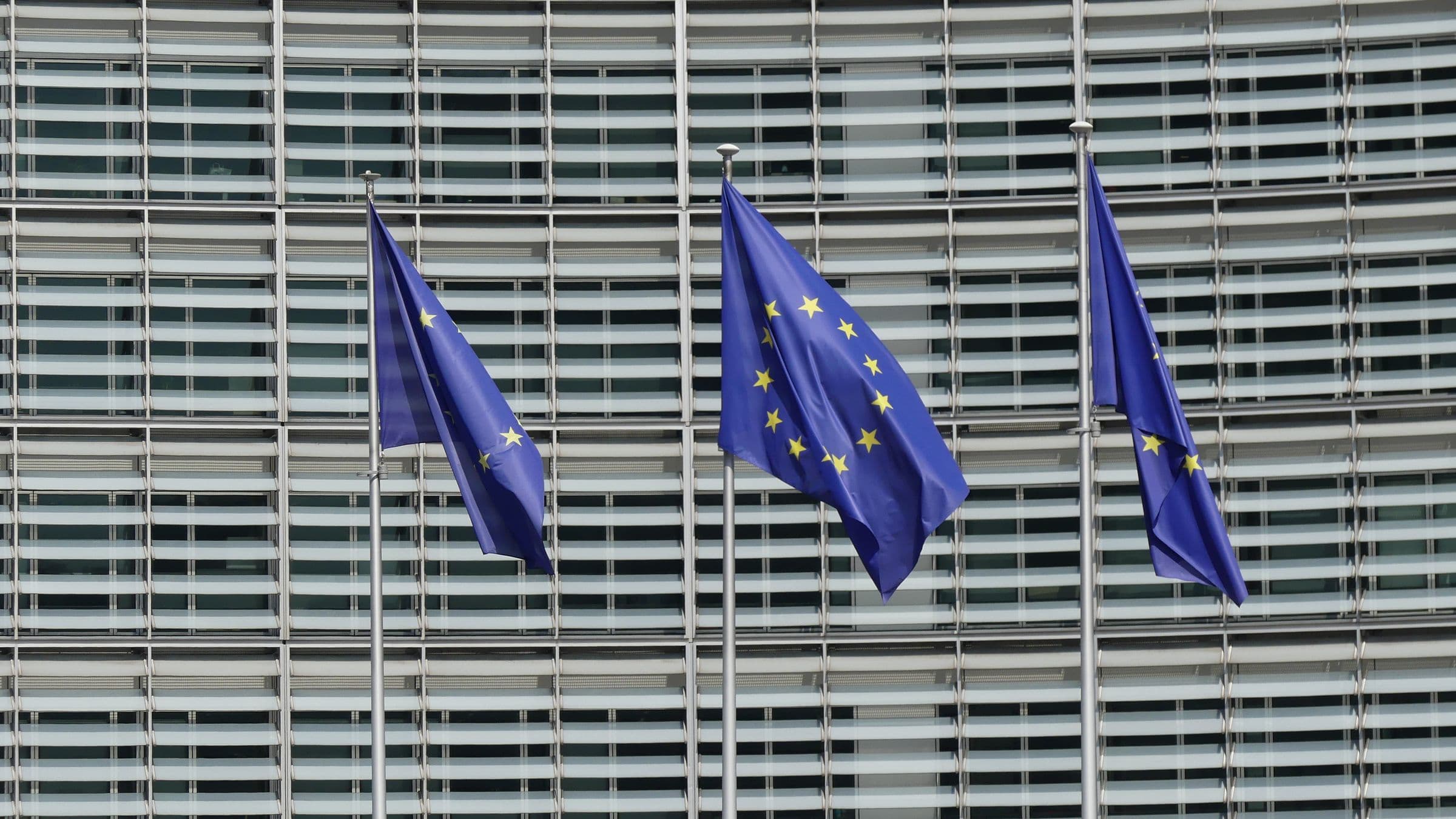 European Union flags flying in front of the Berlaymont building, headquarters of the European Commission in Brussels