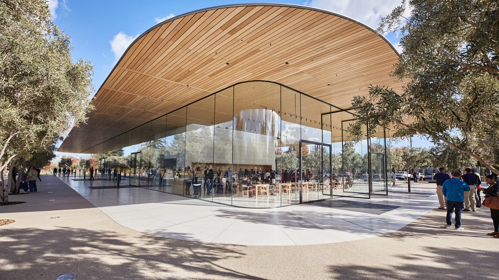 The glass-walled Apple Park Visitor Center under its curved wooden roof in Cupertino