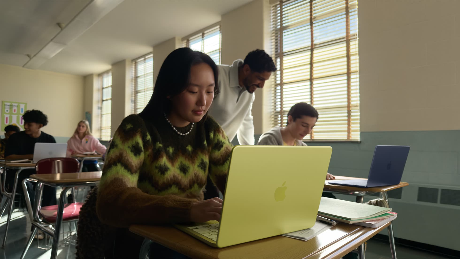 Students working on MacBook Neo laptops in a high school classroom