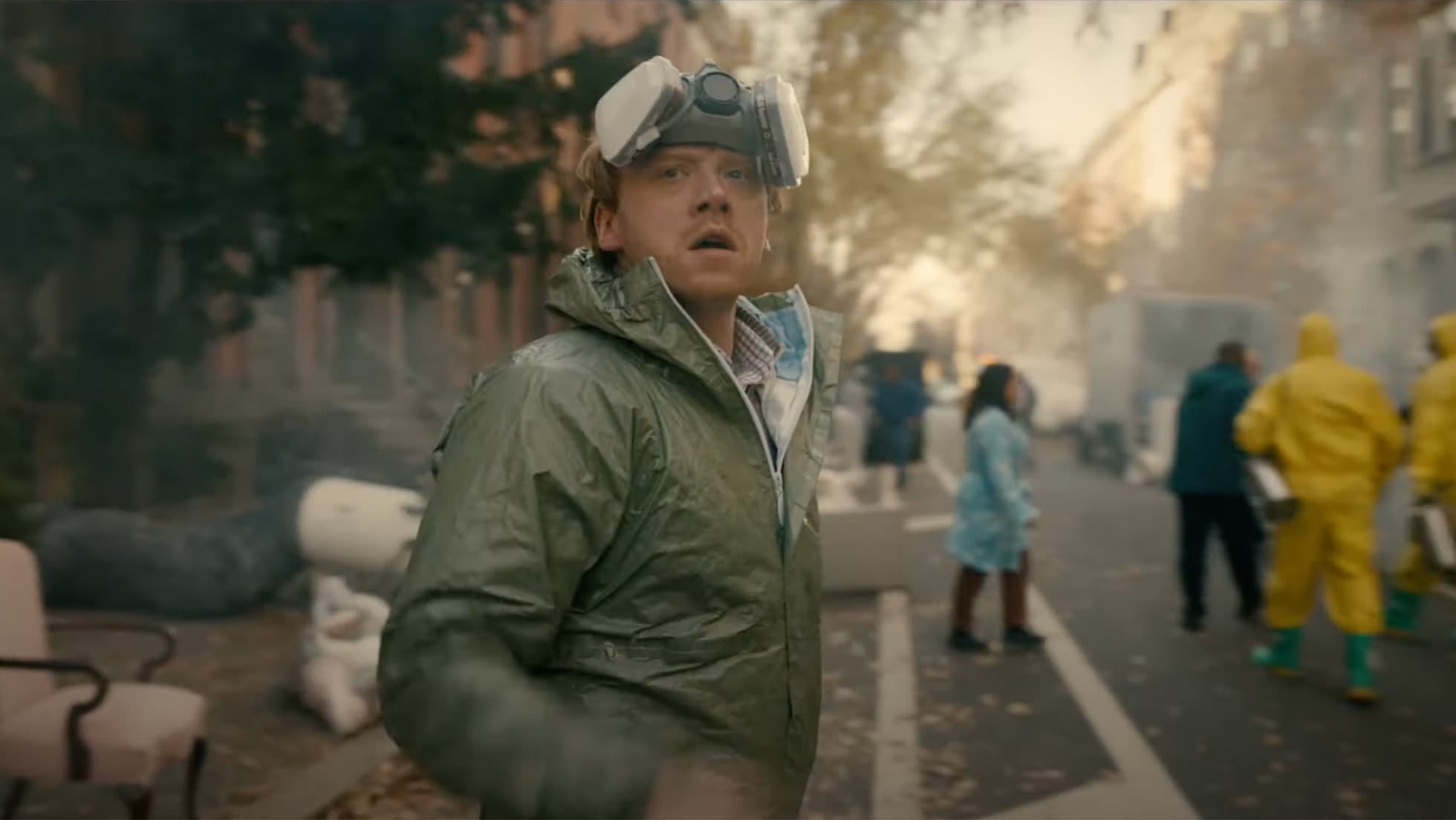 Rupert Grint in a respirator mask on a smoky street in a scene from the Apple TV series Servant