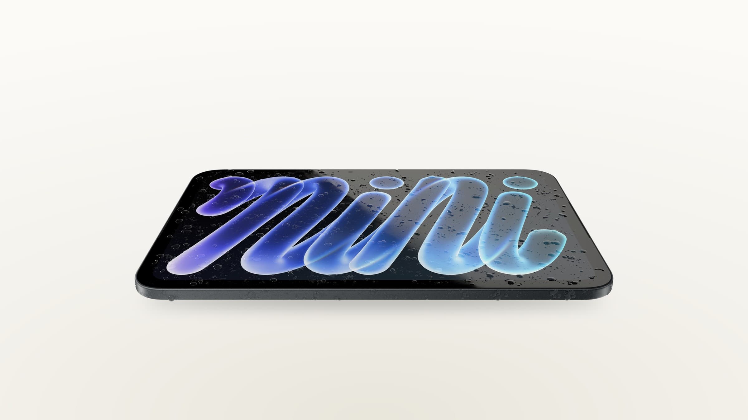 The new iPad mini in midnight with an OLED display, lying flat with water droplets on it, on a light gradient background