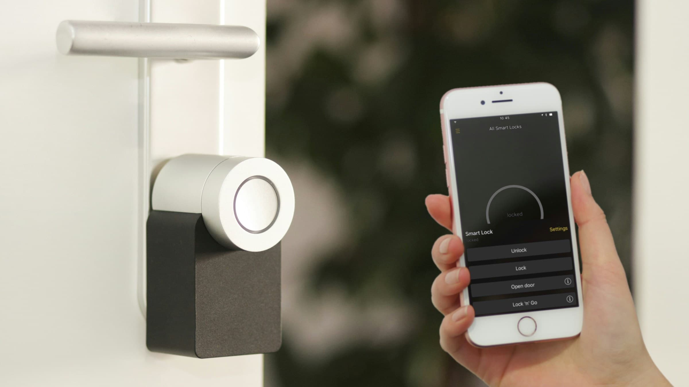 A smart lock on a white door being controlled from an iPhone app