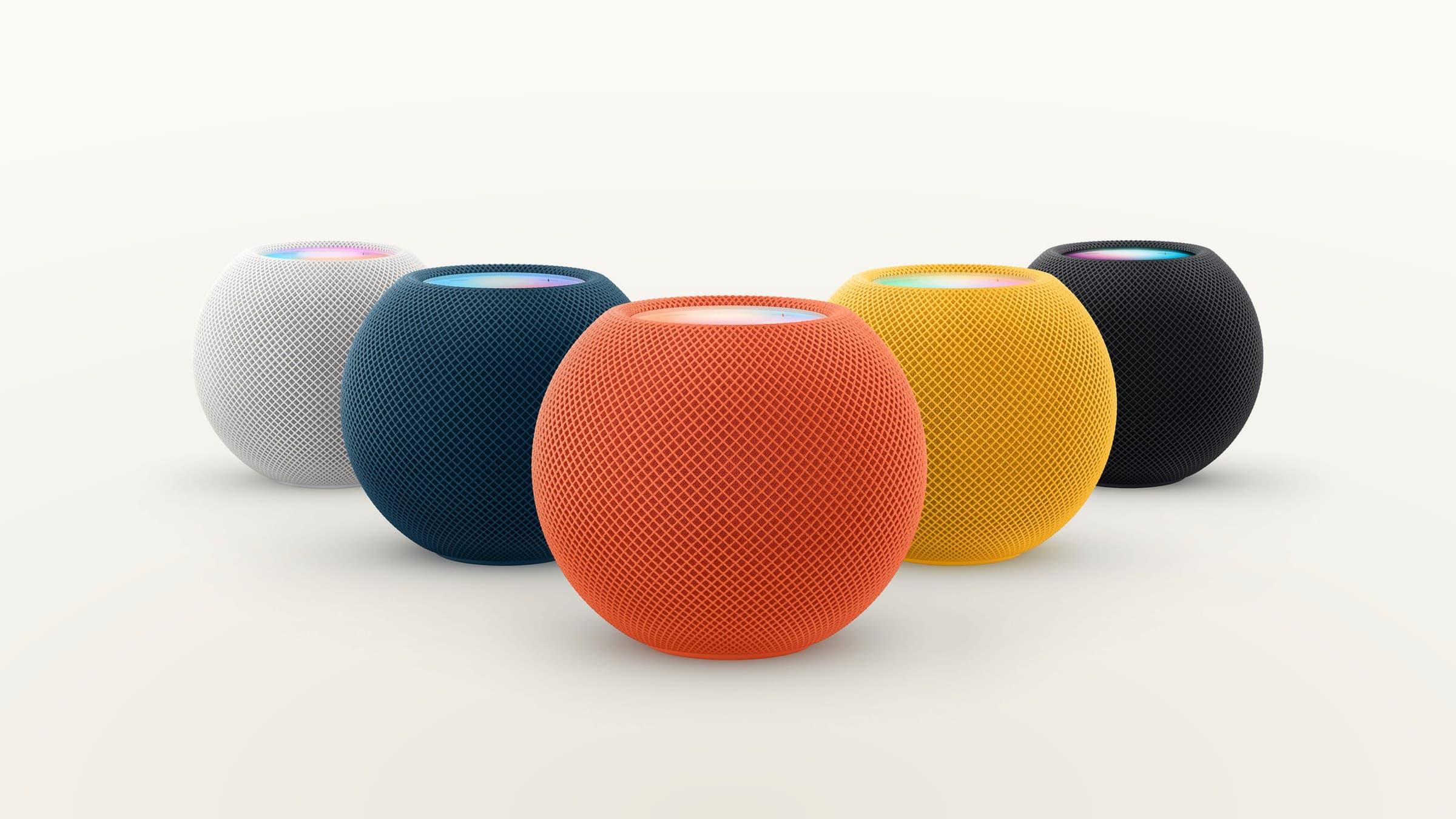 HomePod mini in white, blue, orange, yellow and space grey on a light gradient