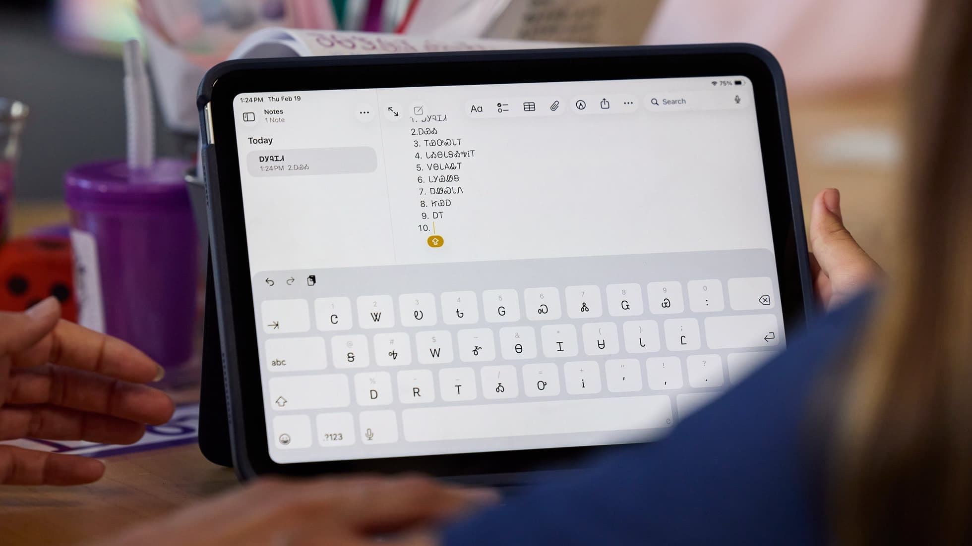 An iPad showing the Cherokee keyboard in the Notes app, with Cherokee syllabary characters typed on screen
